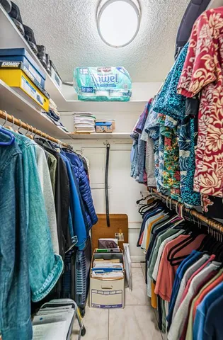 a view of walk in closet with clothes