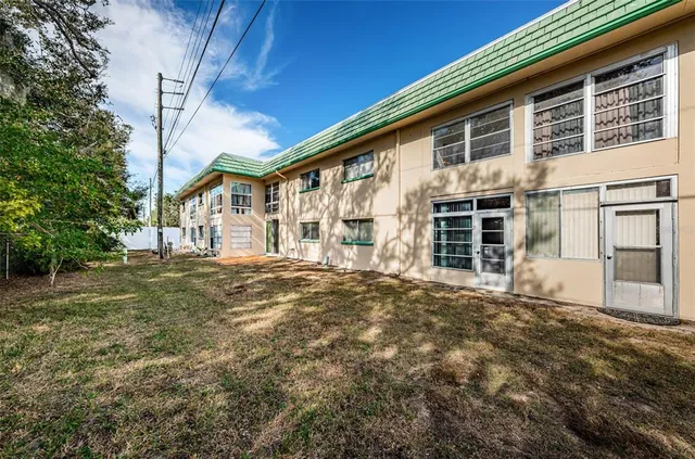 a front view of a house with a large tree