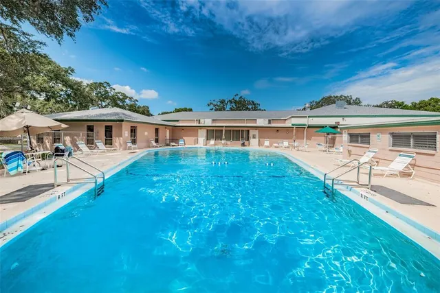 a view of a house with pool and sitting area