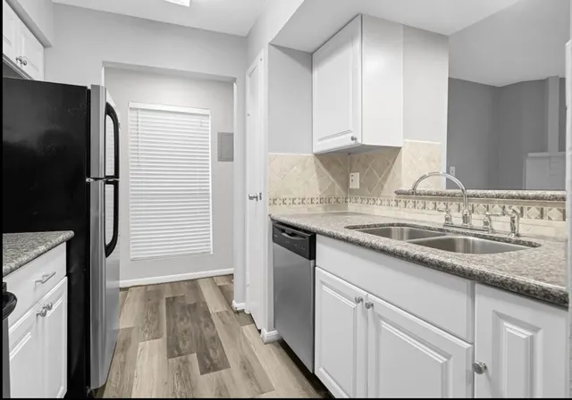 a kitchen with granite countertop a sink and refrigerator