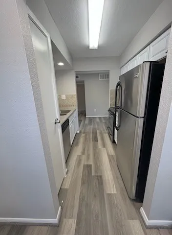 a view of a kitchen from a hallway