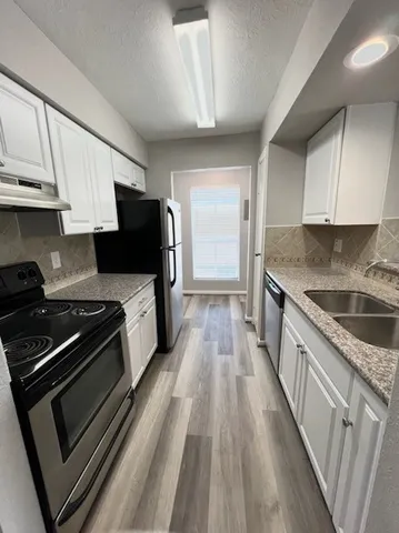 a kitchen with stainless steel appliances kitchen island granite countertop a stove a sink and a refrigerator