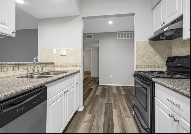 a kitchen with a sink stove and cabinets