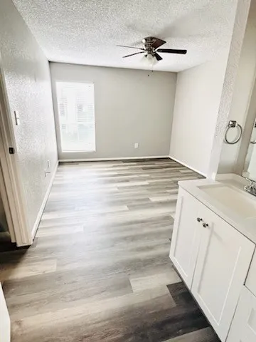 a view of a livingroom with an empty space a fireplace wooden floor and staircase