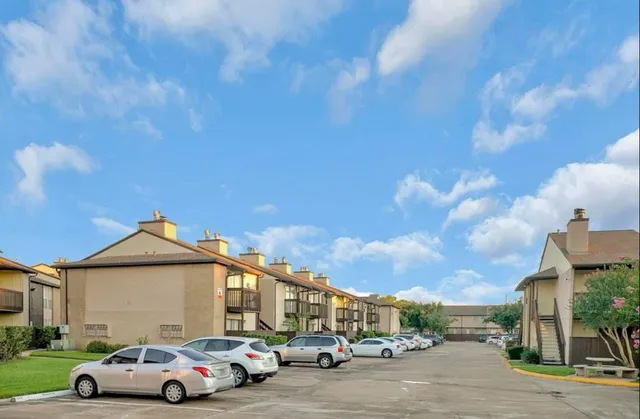 a front view of a house with a garden and parking