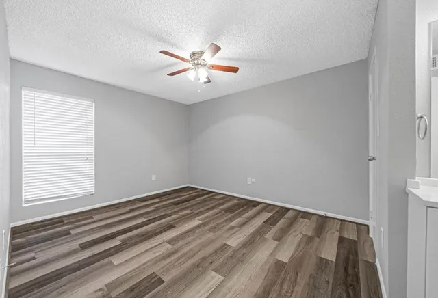 a view of a room with wooden floor and fan