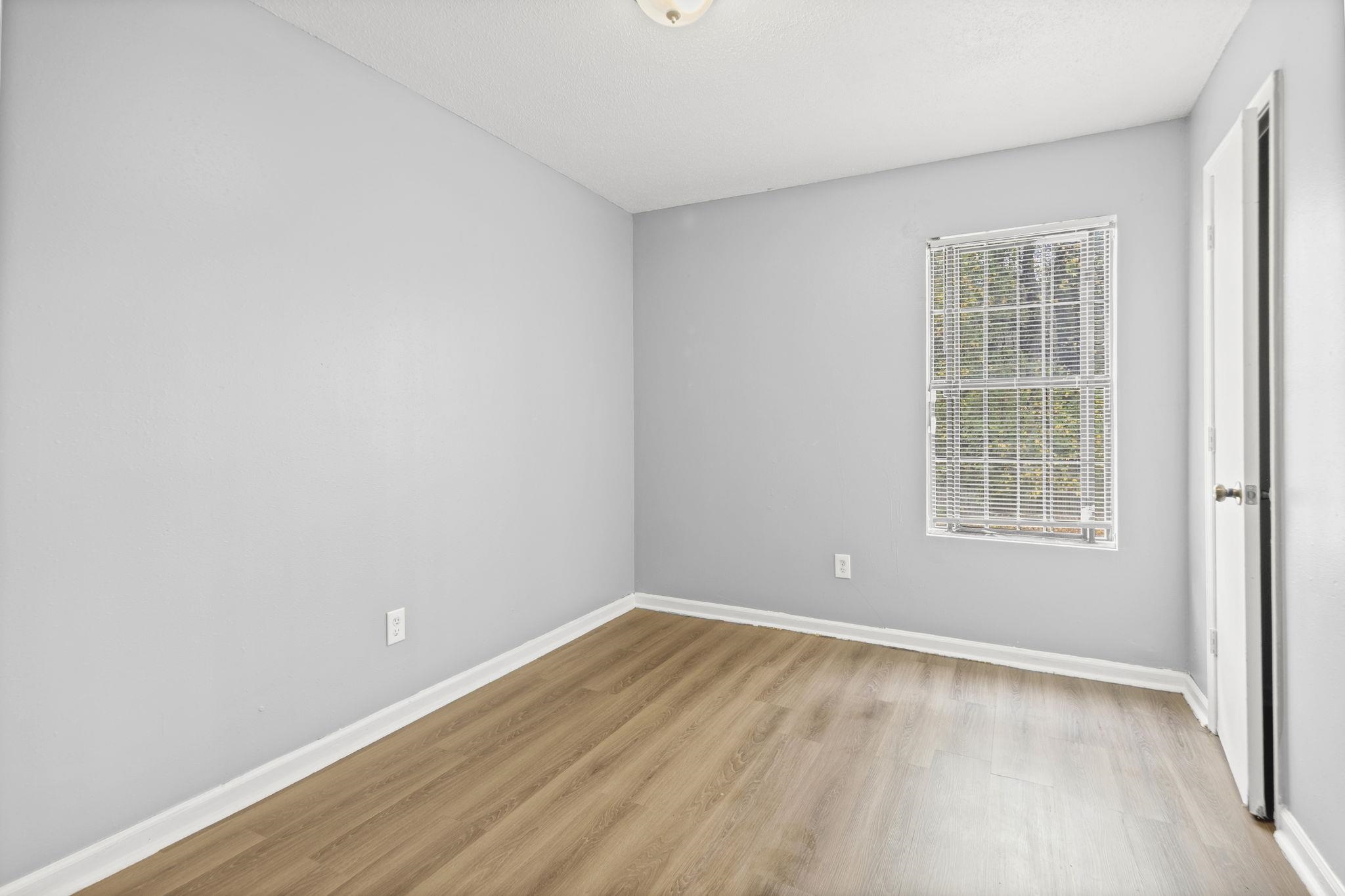 3480 Tallyho Road Memphis, TN 38128 - Photo 10 of 20 wooden floor in an empty room with a window