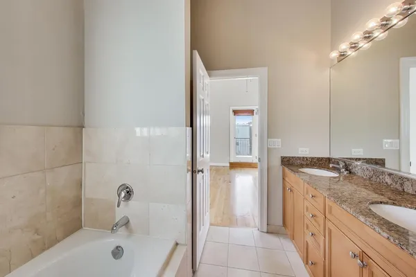 a bathroom with a granite countertop bathtub shower sink and mirror