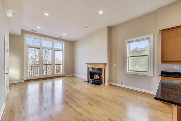 a view of a livingroom with a fireplace wooden floor and a window