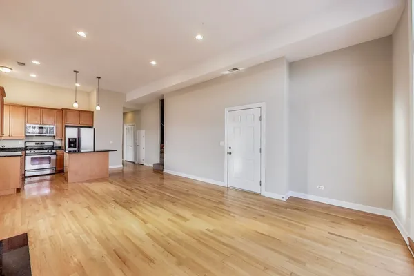 a view of kitchen with kitchen island a sink wooden floor and stainless steel appliances