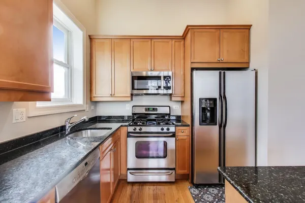a kitchen with granite countertop a stove and a refrigerator