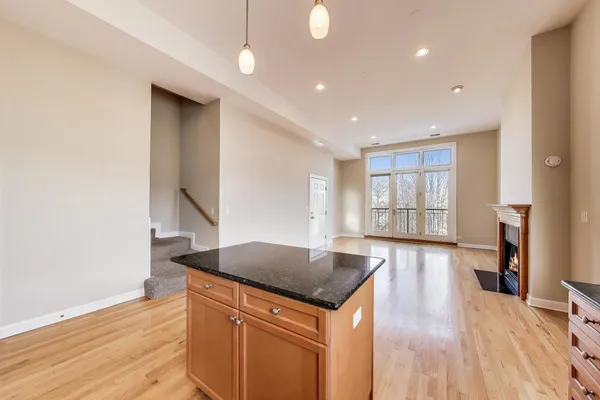 a kitchen with stainless steel appliances granite countertop a refrigerator a sink and a stove with wooden floors