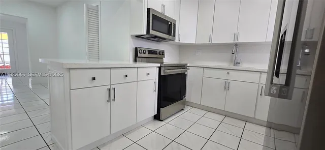 a kitchen with white cabinets and white appliances