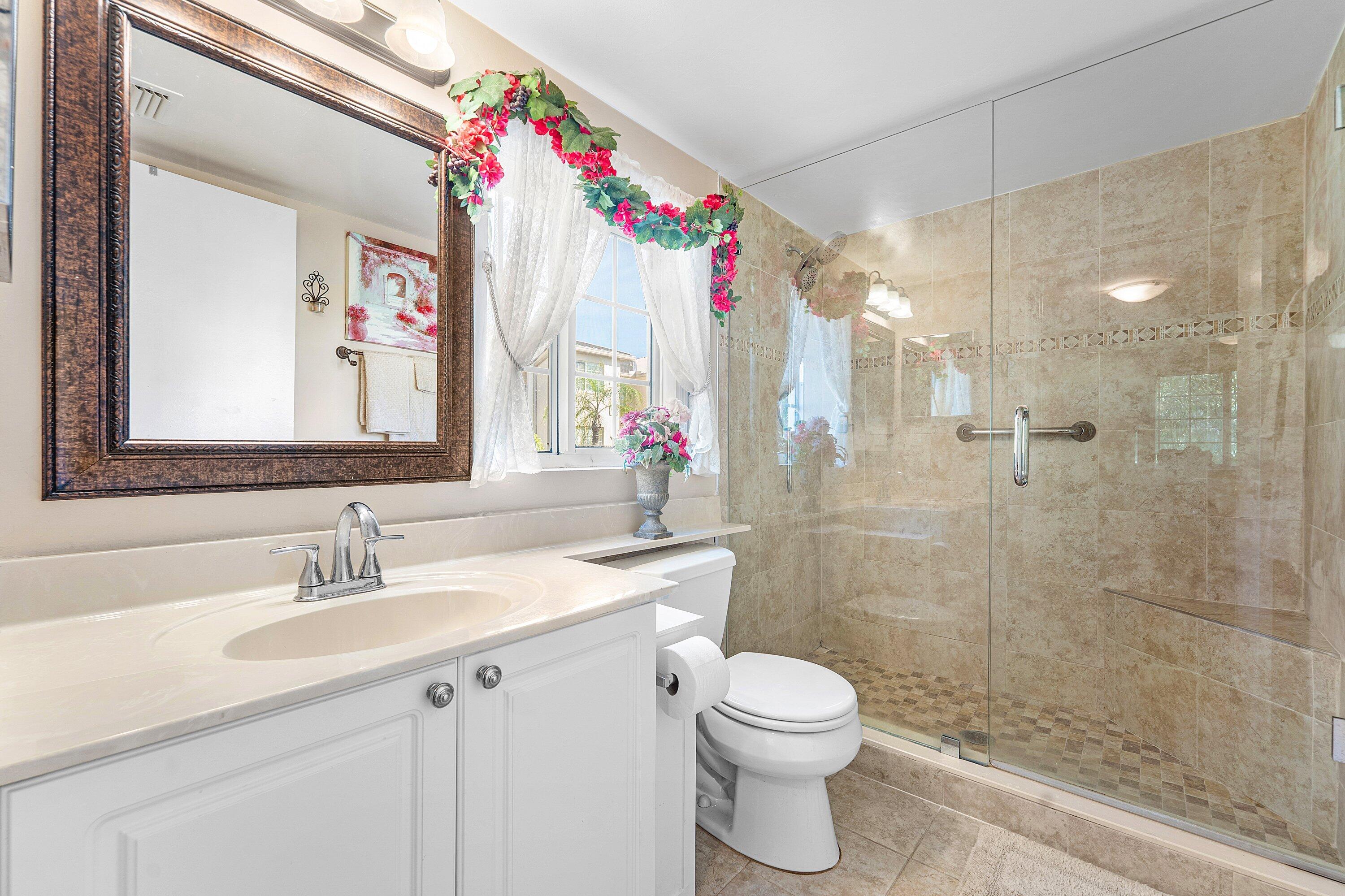 1000 Crestwood Court South, Unit 1015 Royal Palm Beach, FL 33411 - Photo 13 of 21 a bathroom with a sink vanity mirror and toilet