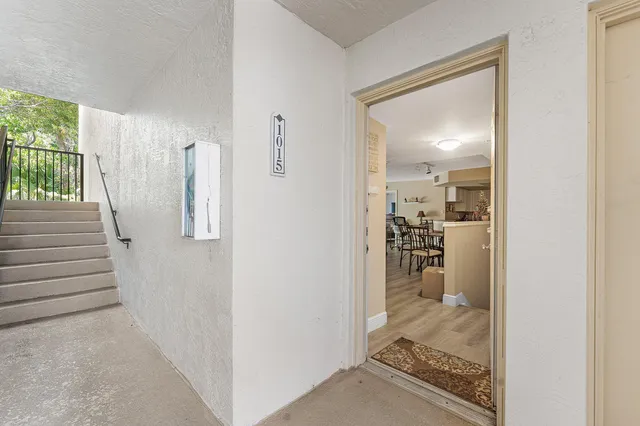 a view of a hallway with wooden floor and a living room