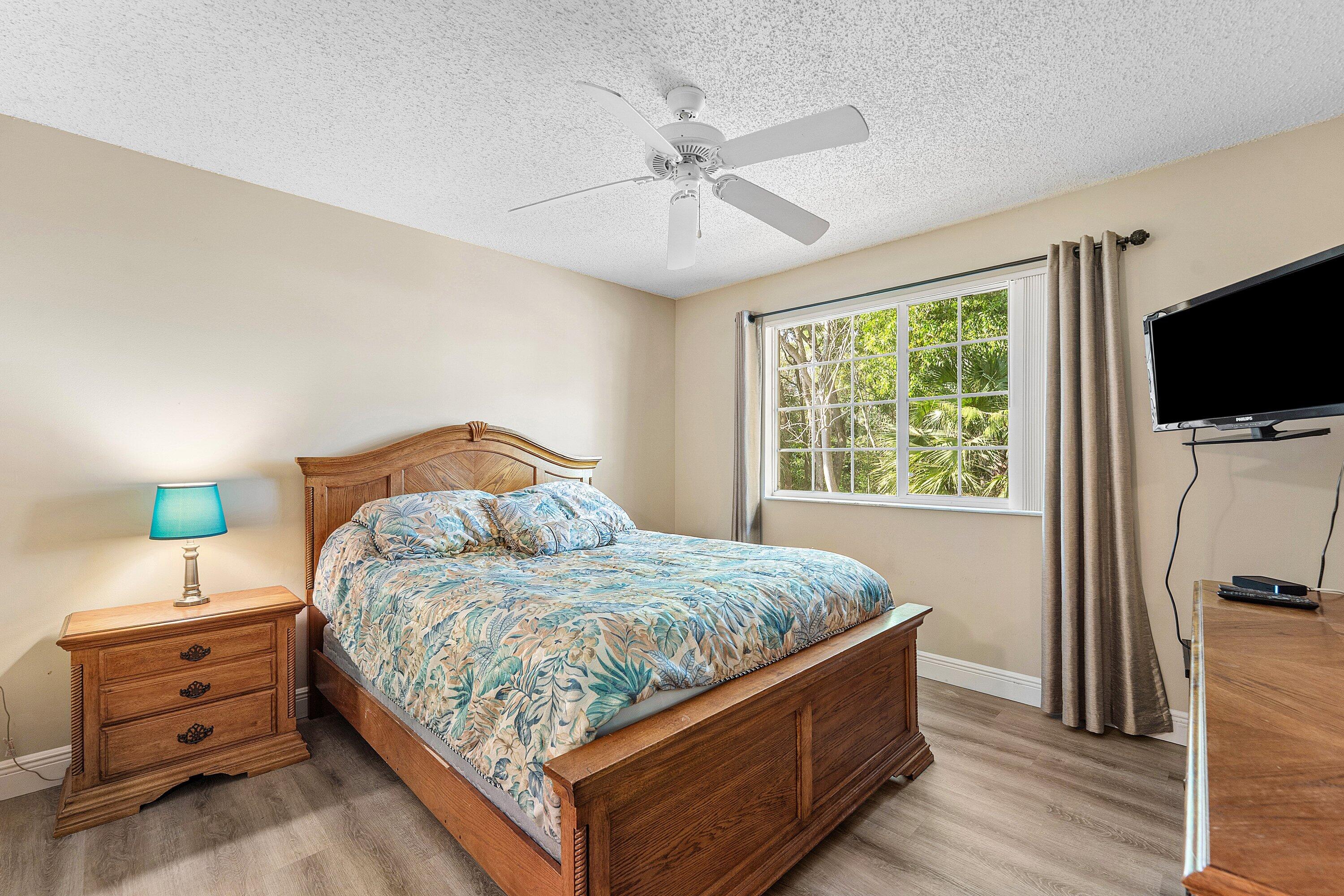 1000 Crestwood Court South, Unit 1015 Royal Palm Beach, FL 33411 - Photo 17 of 21 a bedroom with a bed and a flat screen tv