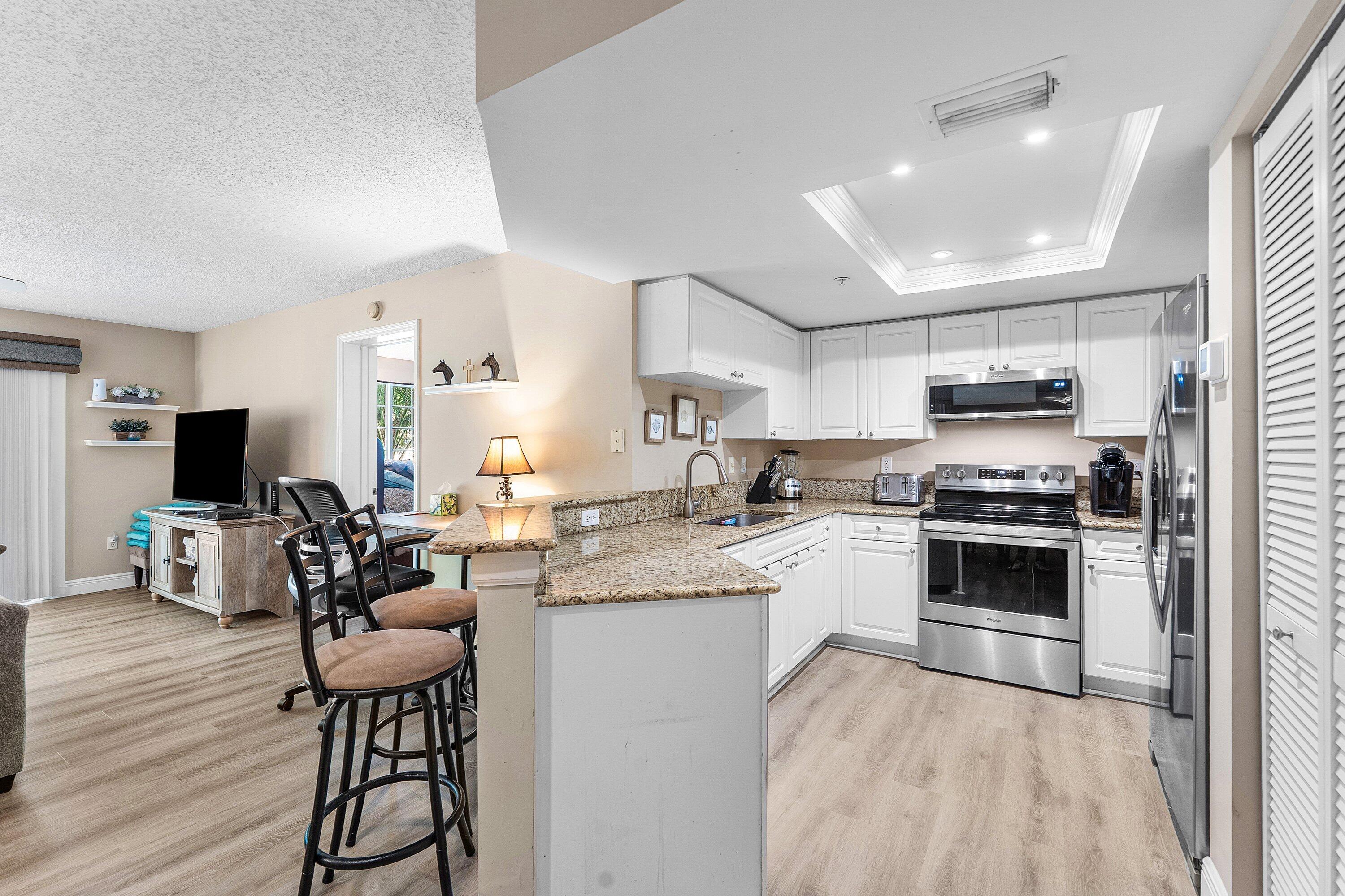 1000 Crestwood Court South, Unit 1015 Royal Palm Beach, FL 33411 - Photo 2 of 21 a kitchen with a sink cabinets and wooden floor