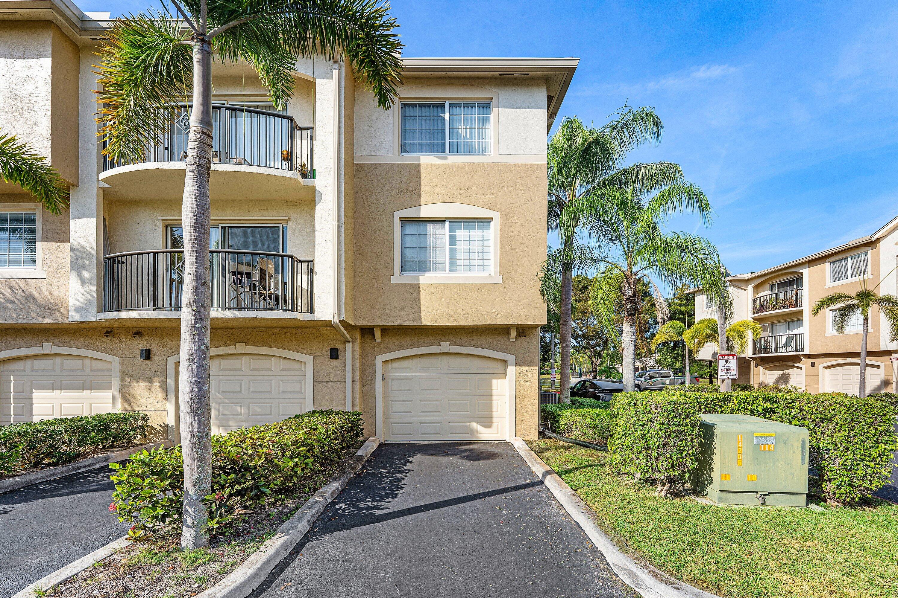 1000 Crestwood Court South, Unit 1015 Royal Palm Beach, FL 33411 - Photo 21 of 21 a front view of a house with a garden and plants