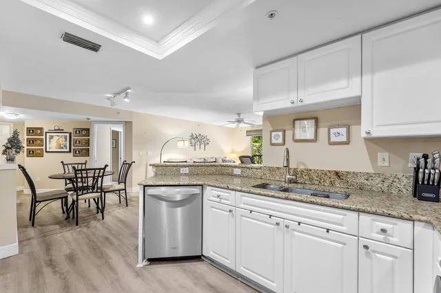 a kitchen with granite countertop white cabinets and white appliances