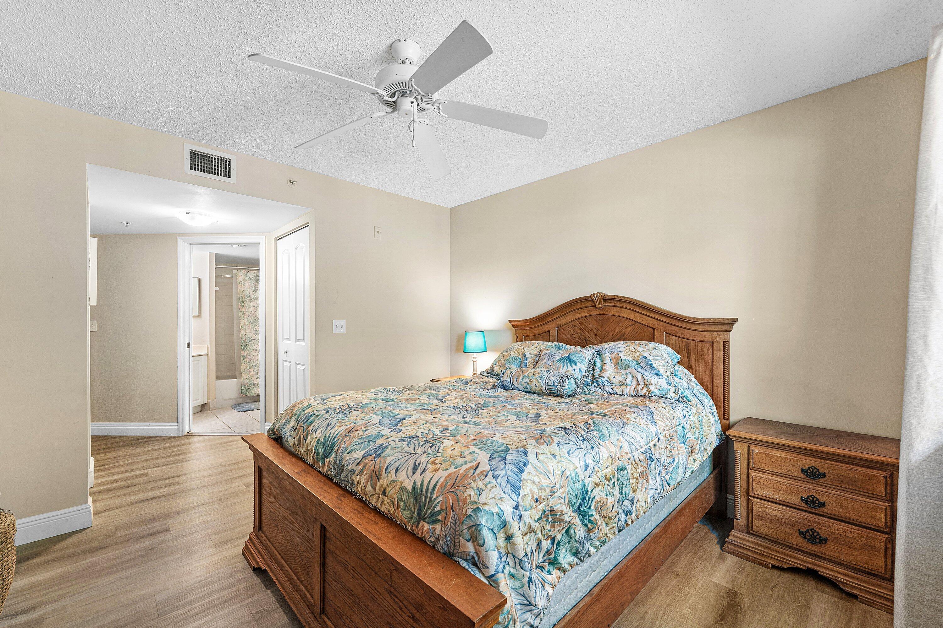 1000 Crestwood Court South, Unit 1015 Royal Palm Beach, FL 33411 - Photo 8 of 21 a bedroom with a bed and a chandelier