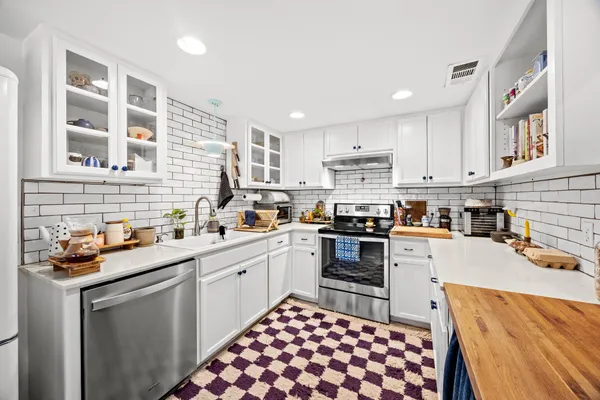 a kitchen with a sink stove and cabinets