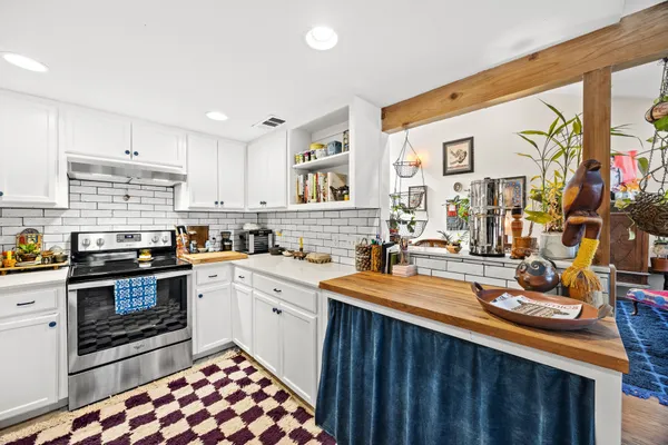 a kitchen with stainless steel appliances granite countertop a sink stove and cabinets