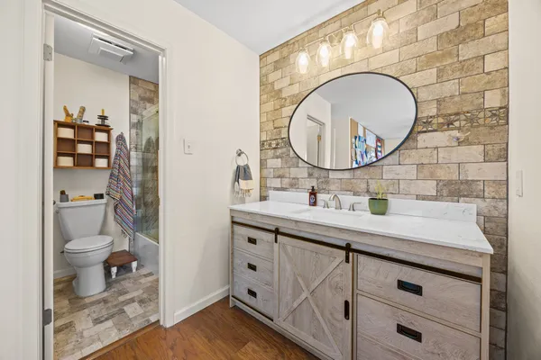 a bathroom with a granite countertop toilet sink and mirror