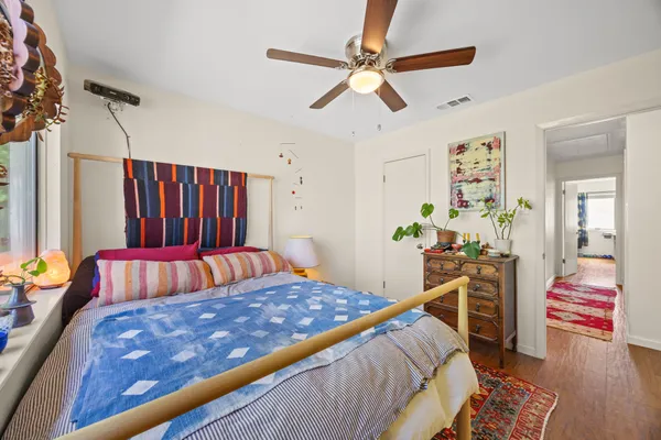 a bedroom with a bed and wooden floor