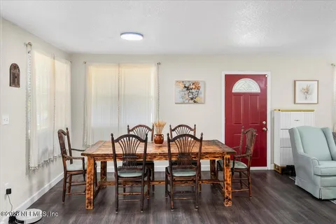 a view of a a dining room with furniture window and wooden floor