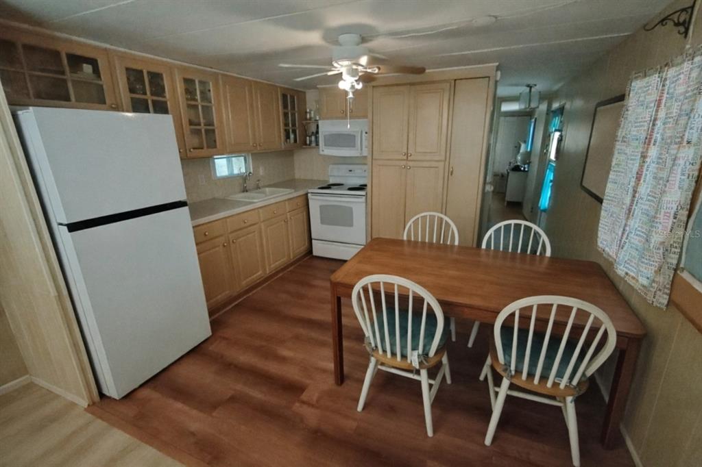 1600 Old Coachman Rd., Unit 806 Clearwater, FL 33765 - Photo 5 of 15 a kitchen with a table chairs refrigerator a sink and dishwasher