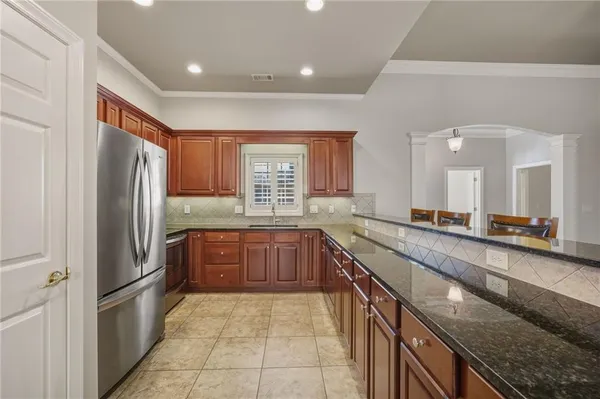 a large kitchen with stainless steel appliances granite countertop a refrigerator and a sink