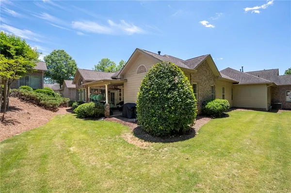 a view of a house with a yard and potted plants