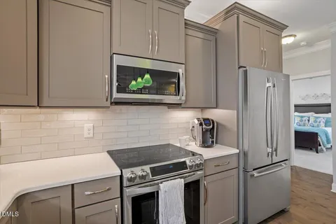 a kitchen with stainless steel appliances white cabinets and a stove top oven