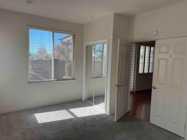 an empty room with a window and a fan