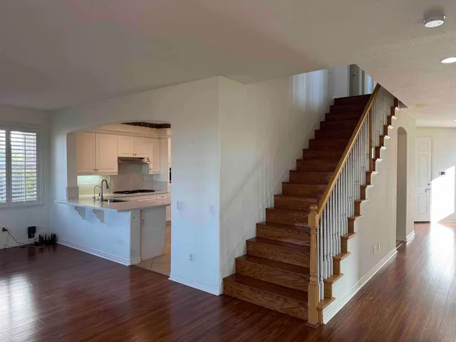 a view of a hallway with wooden floor and staircase