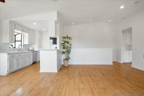 a view of a kitchen with kitchen island a sink stainless steel appliances and cabinets