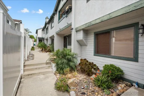 a view of a pathway of house with potted plants
