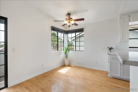 an empty room with windows and ceiling fan