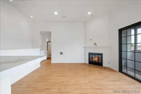 a view of an empty room with a fireplace and a window