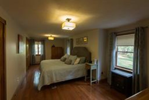 56 Baker Road Salisbury, MA 01952 - Photo 17 of 23 a bedroom with a bed and a chandelier