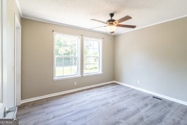 a view of a room with window ceiling fan and wooden floor