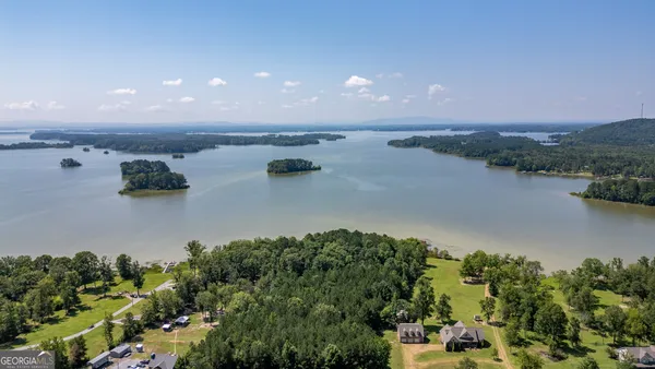 an aerial view of a house with a yard and lake view