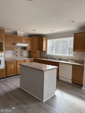 a kitchen with a sink stove top oven and cabinets