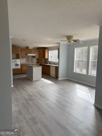 a open kitchen with a sink dishwasher stove and oven with wooden floor