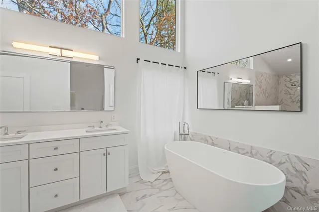 a bathroom with a bathtub shower sink and mirror