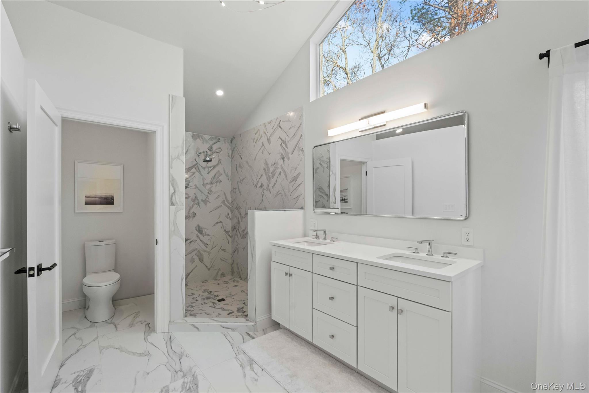7 Midhampton Court Quogue, NY 11959 - Photo 16 of 29 a spacious bathroom with a double vanity sink toilet mirror and double