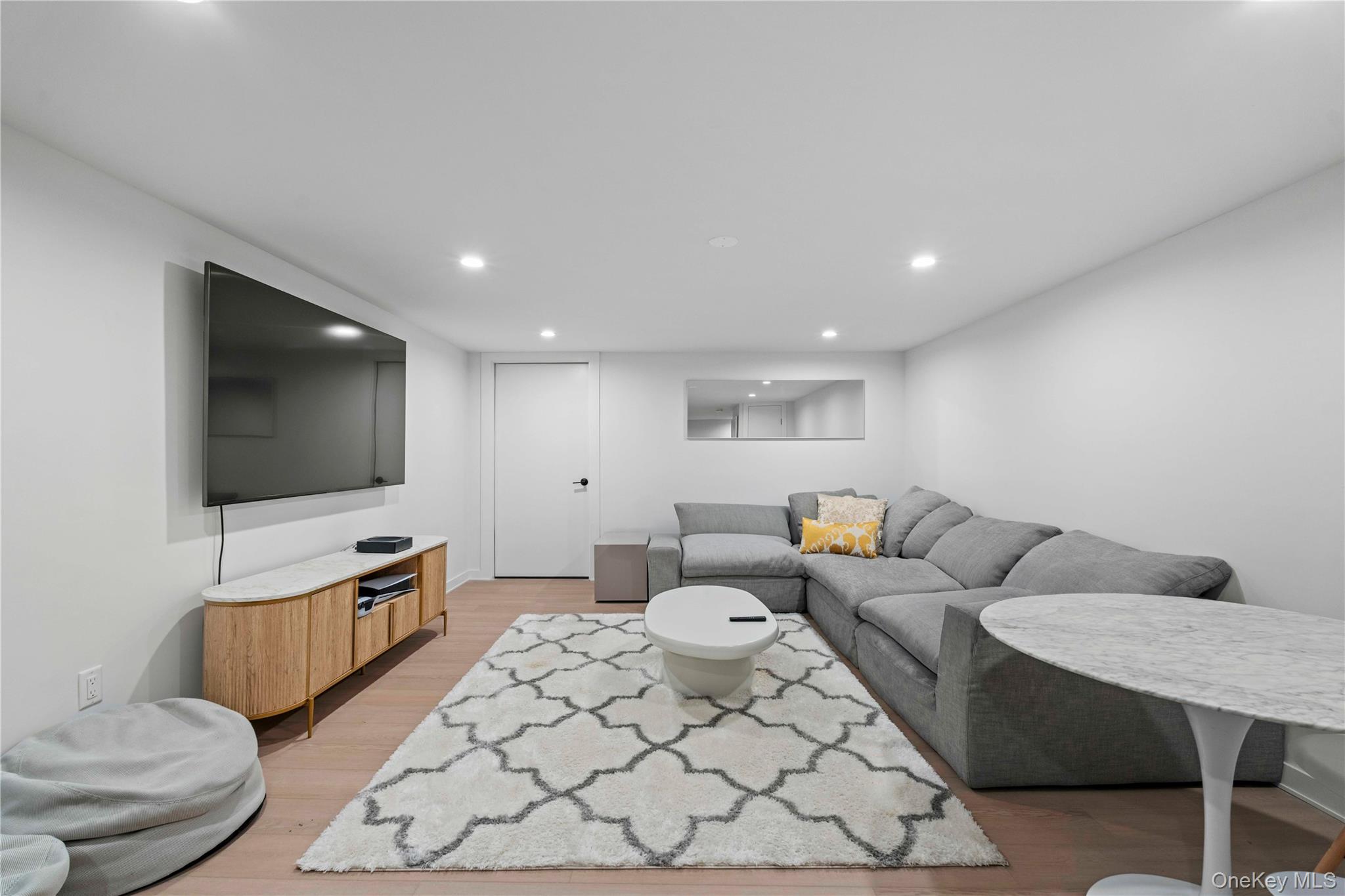 7 Midhampton Court Quogue, NY 11959 - Photo 20 of 24 a living room with furniture and a flat screen tv