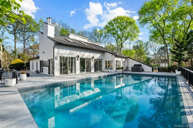 a view of a house with pool and sitting area