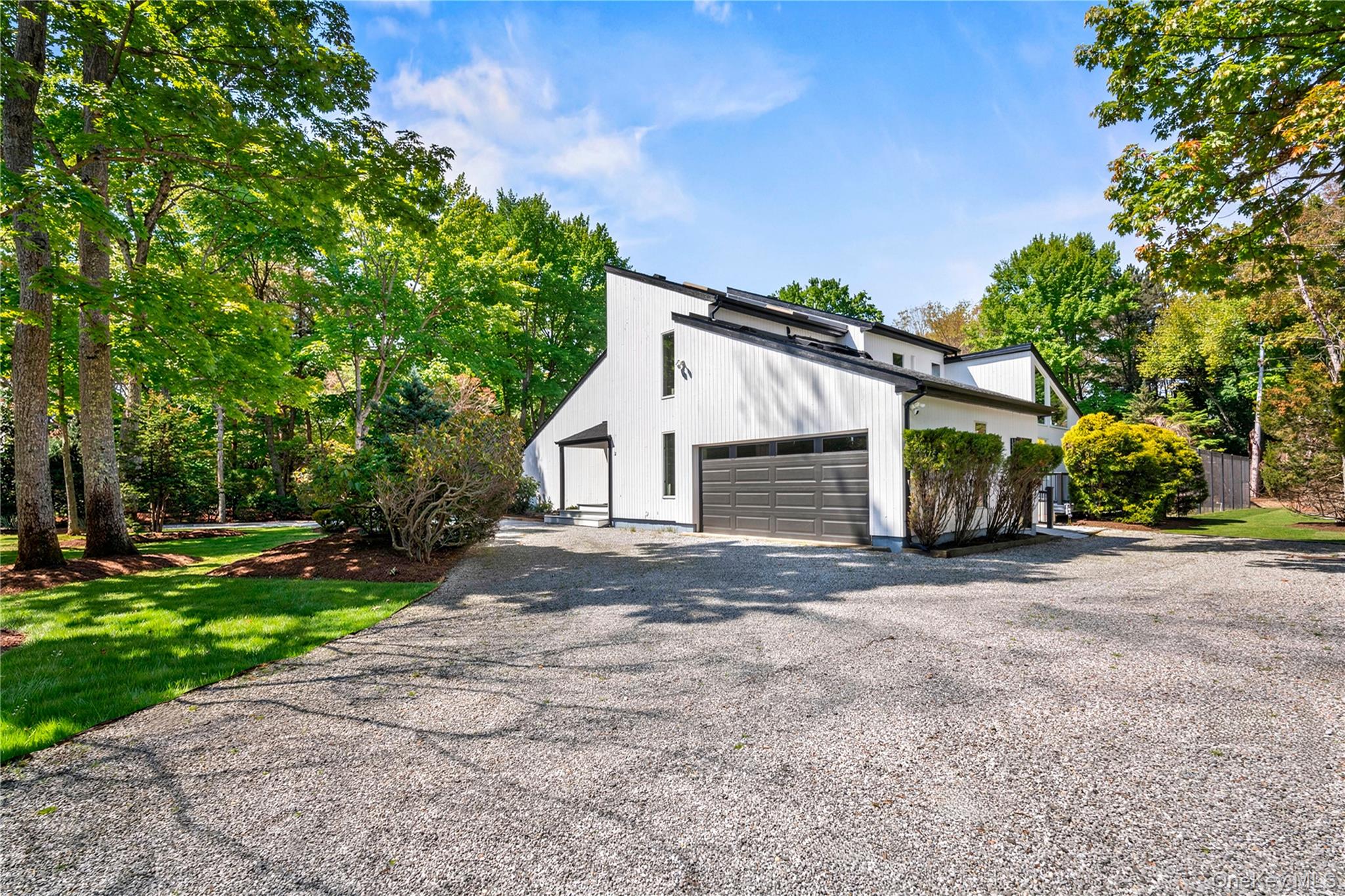 7 Midhampton Court Quogue, NY 11959 - Photo 22 of 29 a front view of a house with a yard and garage