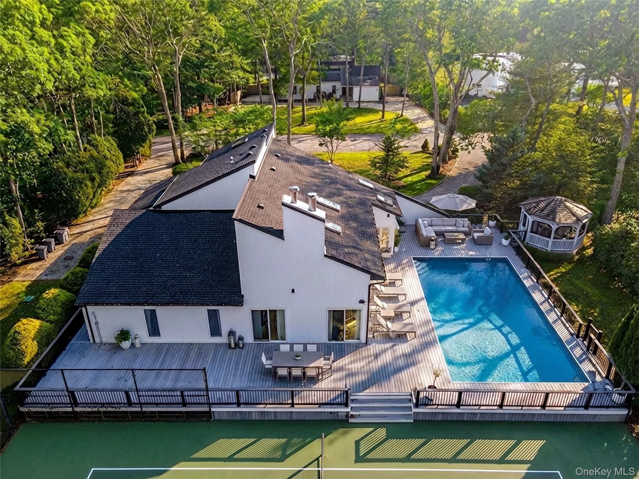 7 Midhampton Court Quogue, NY 11959 - Photo 4 of 24 a small pool with lawn chairs under an umbrella